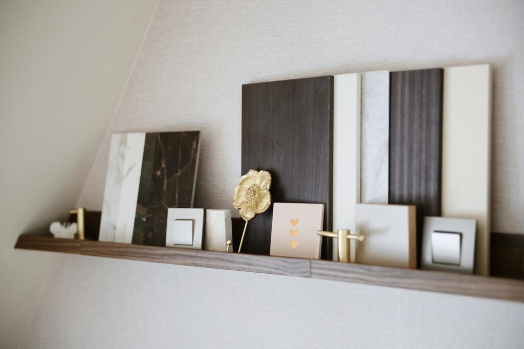 Wandplank met kleur- en materiaalstalen voor interieurstyling, aangevuld met lijsten en accessoires in neutrale tinten